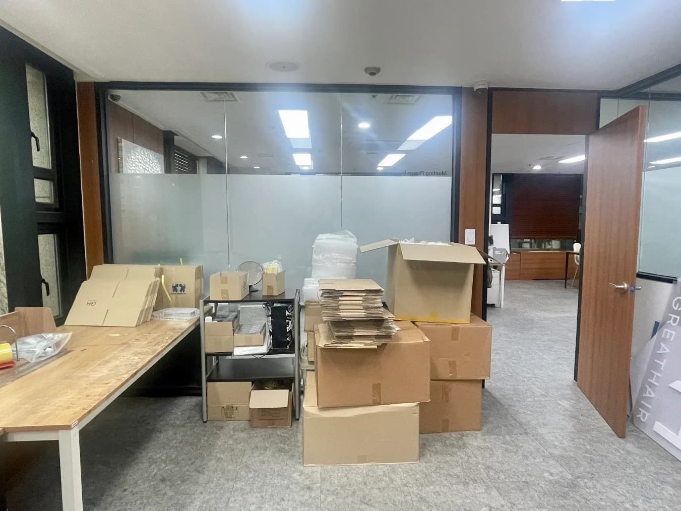 정리 전 사무 공간. 책상 옆에 빈 상자가 쌓여 있다